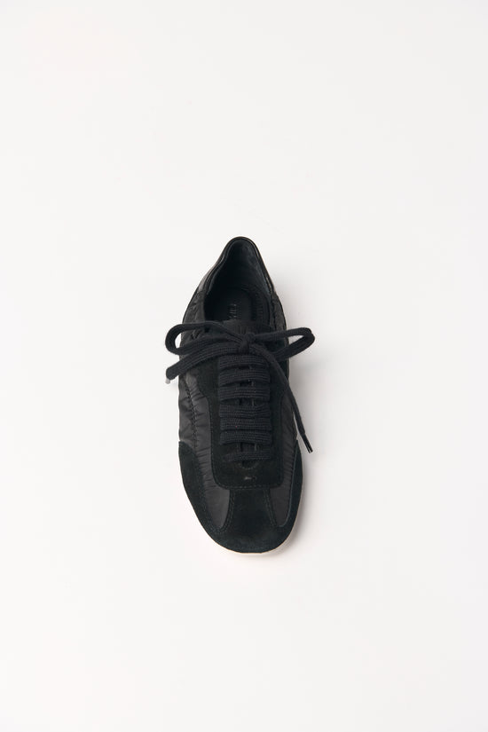 Black nylon and leather sneaker with black laces, shown from above on white background.