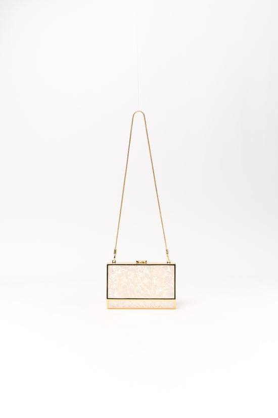 Pearl-textured rectangular clutch with black frame, gold base, and tan shoulder strap.