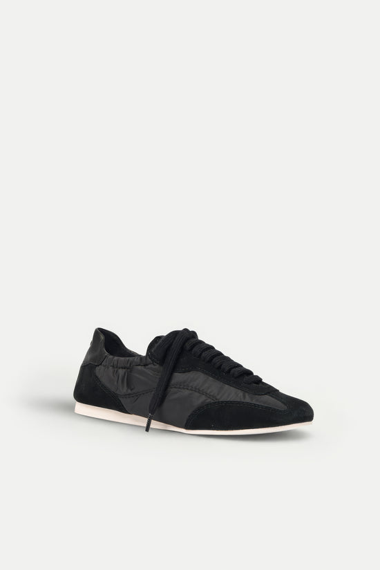 Black nylon and suede sneaker with lace-up closure and white sole, shown in side profile.