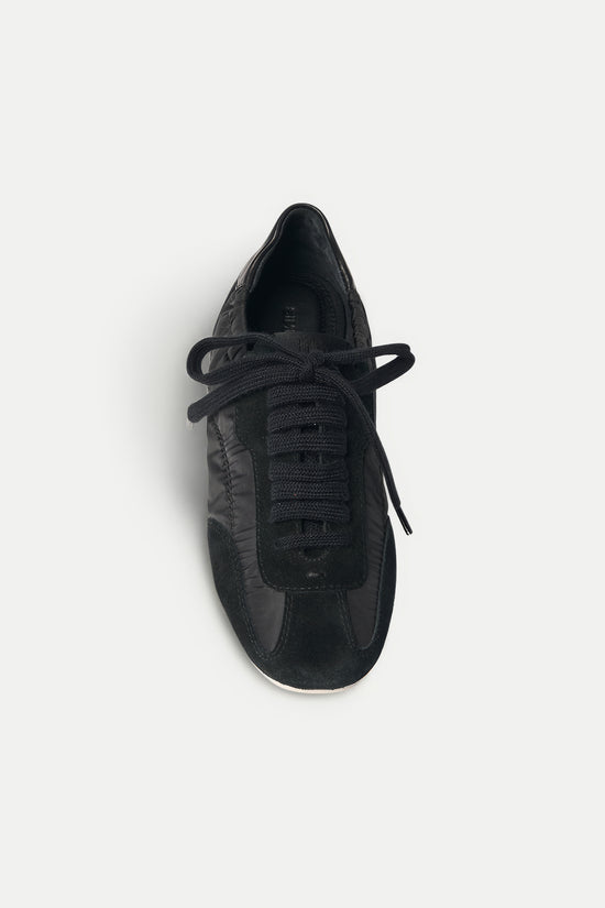 Black sneaker with nylon and leather upper, lace-up closure, and white sole, shown from above.