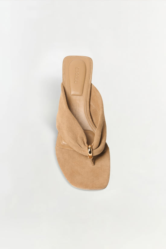 Beige suede block heel mule with gathered fabric detail and gold ring accent, viewed from above.