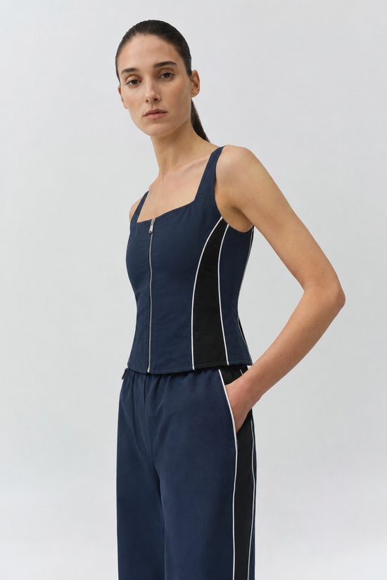 Navy cotton faille bustier top with center front zipper and contrast white piping detail on sides.