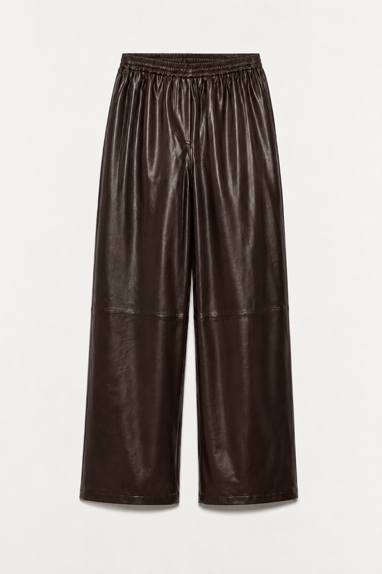 Black leather pants with elasticized waistband and wide-leg silhouette.