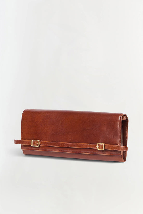 Brown leather clutch wallet with two gold-tone buckle straps and wrist strap.