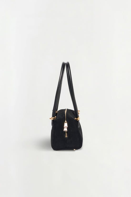 Black suede shoulder bag with dual handles, gold-tone hardware, and center zip closure.
