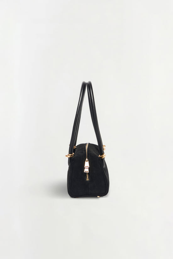 Black suede shoulder bag with dual handles, gold-tone hardware, and center zip closure.