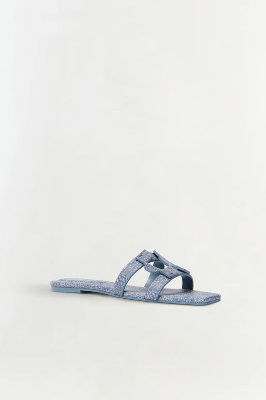 Blue denim flat slide sandal with monogram buckle detail on upper strap.