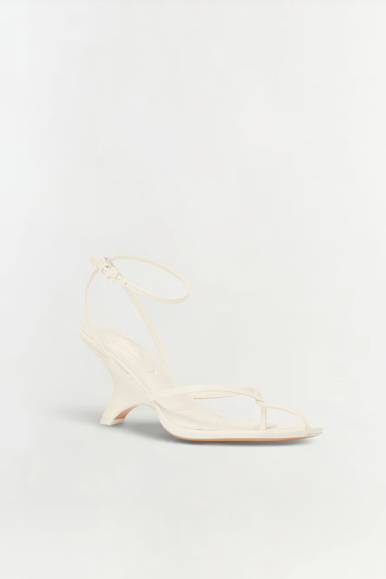 Cream leather strappy wedge sandal with ankle buckle and open toe design.