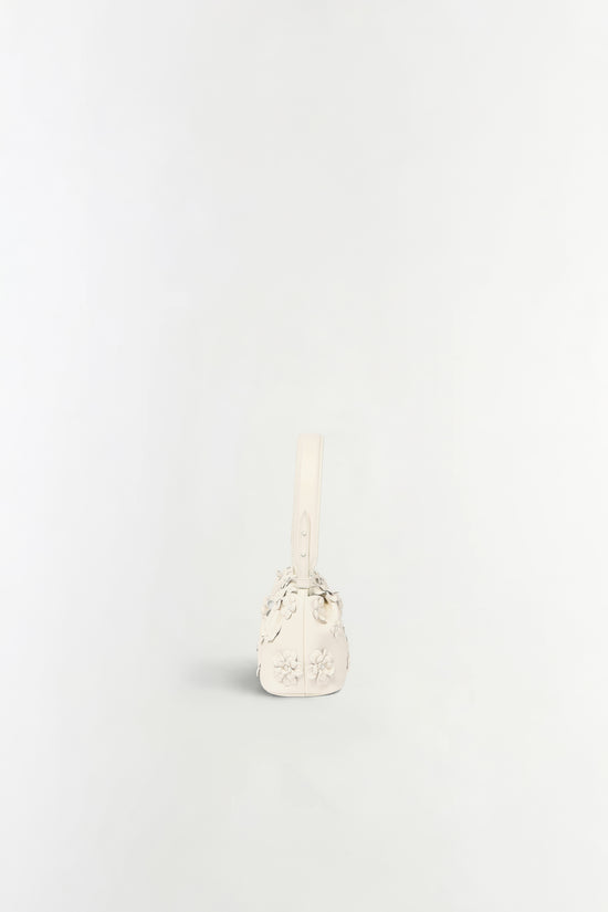 Cream leather shoulder bag with embossed floral details and an adjustable strap.