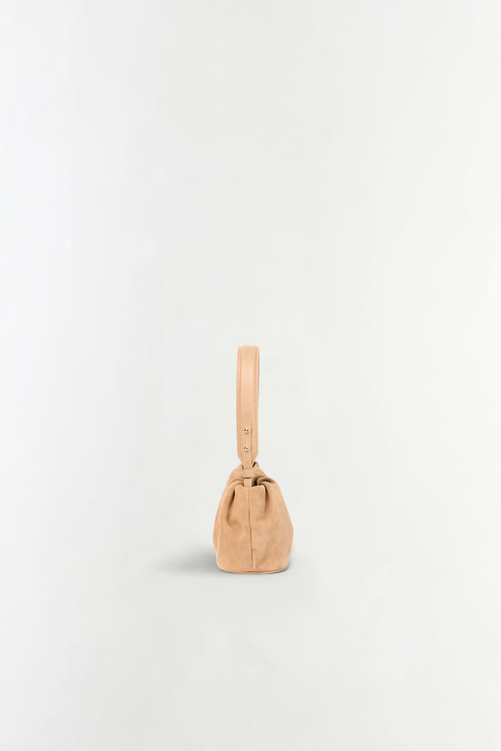 Tan suede shoulder bag with a single adjustable leather strap and gathered top closure.