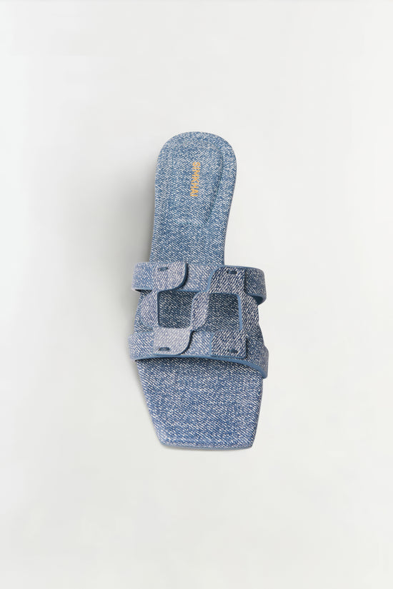 Blue denim flat slide with monogram pattern across the upper band, viewed from above.