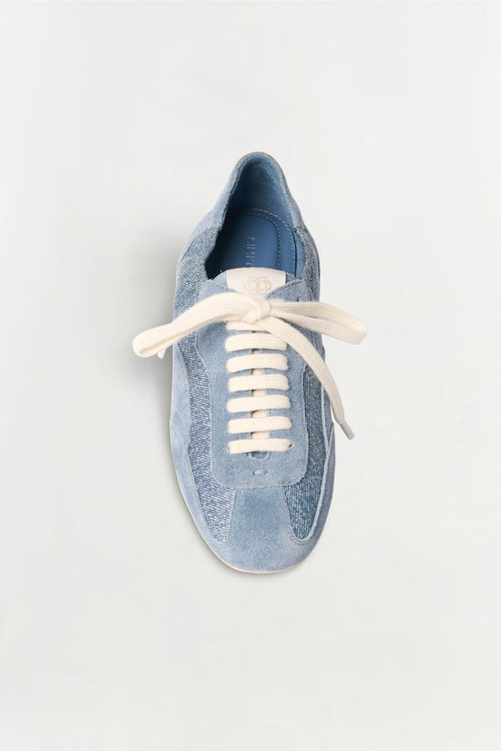 Blue denim and leather sneaker with cream laces, shown from above on white background.