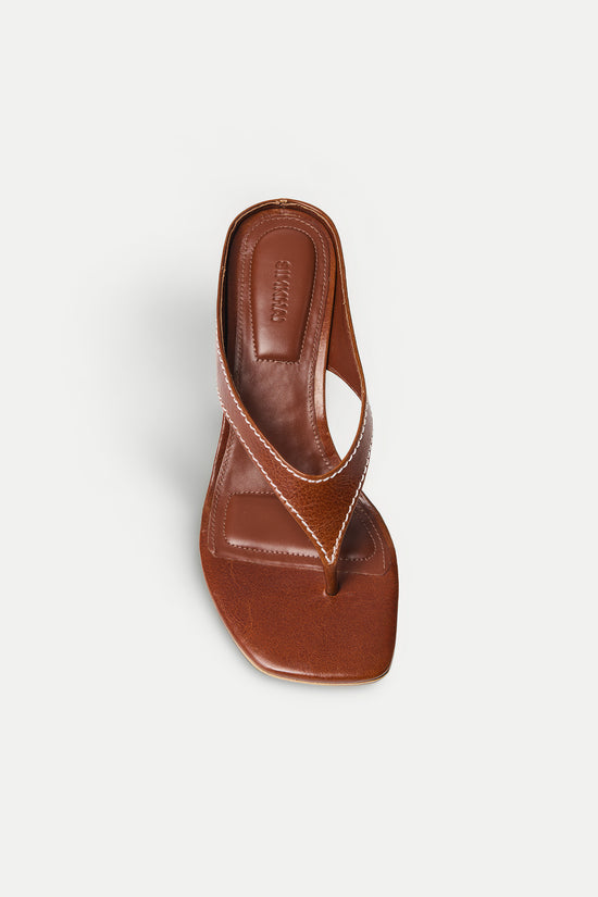 Brown leather thong wedge sandal with v-shaped strap and curved sole, shown from above.